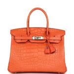 This Birkin is in Orange Poppy Matte Alligator Mississippiensis leather with palladium hardware and features tonal stitching, front flap, two straps with center toggle closure, clochette with lock and two keys, and double rolled handles. The interior is lined with Orange Poppy chevre leather and has a zip pocket with an Hermès engraved zipper pull and an open pocket on the opposite side. Collection: X (2016) Origin: France Condition: Pre-owned; Mint - This bag retains its shape structure. The exterior is clean with overall fading to the alligator skin. There is plastic on the hardware. The interior leather is clean with no signs of wear. Accompanied by: Hermès box, Hermès dustbag, felt, clochette, lock, two keys, clochette dustbag, carebook, raincoat Measurements: 11.75" width x 9.5" height x 6" depth; 4.25" handle drop Free Express shipping We offer free express shipping on all domestic orders via FedEx Express. All shipments are fully insured.